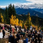 A bride walking down the isle at the Little Nell's Aspen Wedding Deck for a fall wedding ceremony.